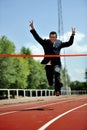 Businessman running on athletic track celebrating victory in work success concept Royalty Free Stock Photo
