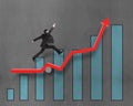 Businessman running and jumping on growth red arrow with chart Royalty Free Stock Photo