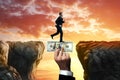 The businessman runs across the chasm along the big hand of the investor. An investor helps a business, a startup. The concept of Royalty Free Stock Photo