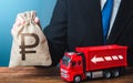 Businessman with russian ruble money bag and truck. Good salaries for drivers. High income of the transport business and the