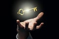 Businessman`s hand catches or holds an old golden glowing key, grab luck, key to success concept Royalty Free Stock Photo