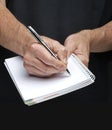 Businessman's hand with a gilded pen writing somet