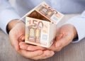 Businessman's hand holding house made of euro notes Royalty Free Stock Photo