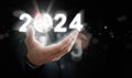 Businessman`s hand holding the year 2024 with light blub, dart, and target. Starting the new year, business, project, path, goal, Royalty Free Stock Photo