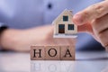 Businessman Placing House Models On HOA Cubic Blocks