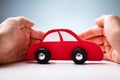 Businessman`s Hand Protecting Red Toy Car Royalty Free Stock Photo