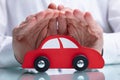 Businessman`s Hand Protecting Red Toy Car Royalty Free Stock Photo