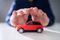 Businessman`s Hand Protecting Red Toy Car Royalty Free Stock Photo