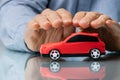 Businessman\'s Hand Protecting Red Toy Car Royalty Free Stock Photo