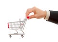 Businessman's hand pushes shopping cart