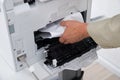 Businessman`s Hand Removing Paper Stuck In Printer