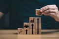 Businessman`s hand selects a target icons on wooden cubes, business development concept.