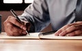 The businessman`s hand is signing or writing documents. Royalty Free Stock Photo