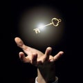 A businessman`s hand is trying to grab a golden key a symbol of good luck and wealth Royalty Free Stock Photo