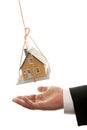 Businessman's Hand Under Dangling House