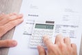 Businessman's hands calculating invoice at desk Royalty Free Stock Photo