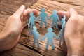 Businessman`s Hands Covering Paper Team On Table