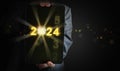 Businessman`s hands holding a tablet with the year changing from 2023 to 2024. Time to start new year, business, project, path,