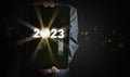 Businessman`s hands holding a tablet with the year changing from 2022 to 2023. Time to start new year, business, project, path,