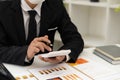 Businessman`s hands pressing a calculator, calculating, analyzing, graphing, charting, accounting worker working on a laptop. A ba