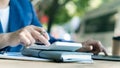 Businessman`s hands pressing a calculator, calculating, analyzing, graphing, charting, accounting worker working on a laptop. A ba