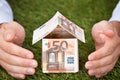 Businessman's Hands Protecting Euro House On Grassy Land Royalty Free Stock Photo