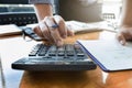 Businessman`s hands using calculator and Financial data analyzing on wooden desk at the office Royalty Free Stock Photo