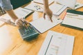 Businessman`s hands using calculator and Financial data analyzing on wooden desk at the office Royalty Free Stock Photo