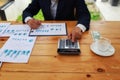 Businessman's hands using calculator and Financial data analyzing on wooden desk at the office Royalty Free Stock Photo
