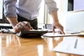 Businessman`s hands using calculator and Financial data analyzing on wooden desk at the office Royalty Free Stock Photo