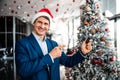 Businessman in a Santa hat standing indoors Royalty Free Stock Photo