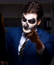 Businessman with scary face mask working late in office Royalty Free Stock Photo