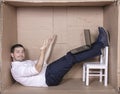 Businessman seated in his cramped office satisfied with his work