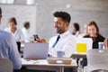 Businessman Sending Text Message In Mobile Phone In Office