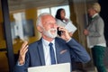 Mature businessman working on laptop. Handsome mature business leader sitting in a modern office Royalty Free Stock Photo