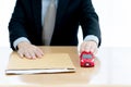 A Businessman sent filing for car loan. document and small red car