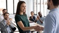 Male boss handshake female employee greeting with success at meeting