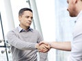 Businessman shaking hands with competitor