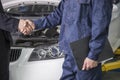 Businessman shaking hands with Mechanic in Auto Repair Shop Royalty Free Stock Photo