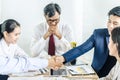 Businessman shaking hands to seal a deal with his partner and colleagues after finishing up meeting