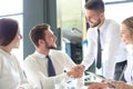 Businessman shaking hands to seal a deal with his partner and colleagues in office Royalty Free Stock Photo