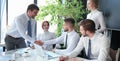 Businessman shaking hands to seal a deal with his partner and colleagues in office Royalty Free Stock Photo