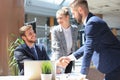 Businessman shaking hands to seal a deal with his partner and colleagues in office Royalty Free Stock Photo