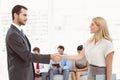 Businessman shaking hands with woman besides people waiting for interview Royalty Free Stock Photo