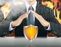 Businessman and shield with fire background