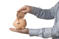 Businessman in shirt try to put a giant american penny into a small piggy bank. Isolated on white background Royalty Free Stock Photo