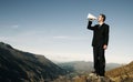 Businessman Shouting on the Top of the Mountain