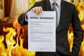 Businessman show home insurance policy with fire Royalty Free Stock Photo
