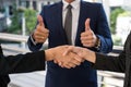 Businessman show thumb up and two businesswoman shaking hands for demonstrating their agreement to sign agreement or contract be Royalty Free Stock Photo