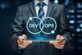 Businessman showcases DevOps concept on tablet for software development and IT operations synergy Royalty Free Stock Photo